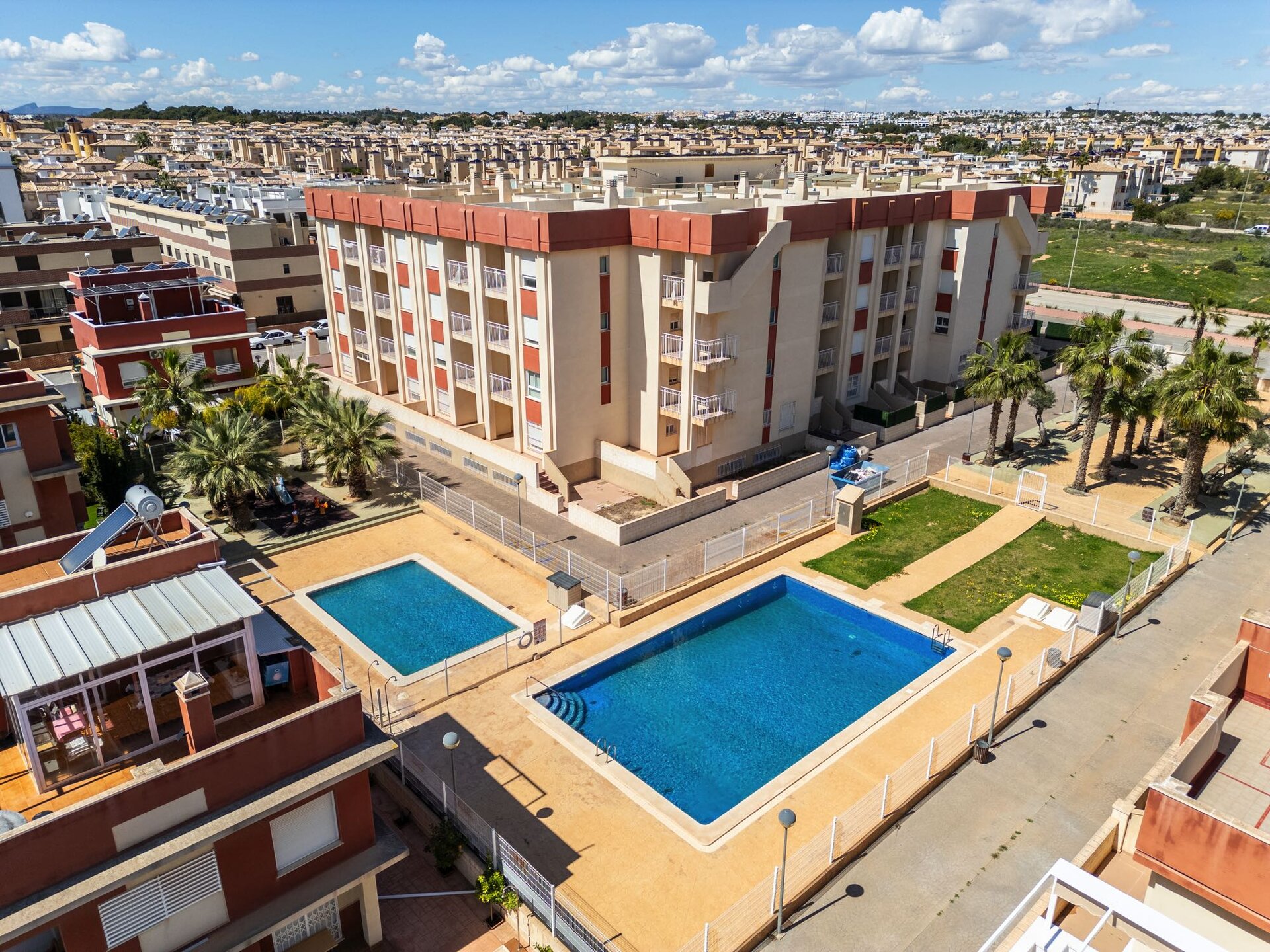 Perla del Mar — communal swimming pools and garden area